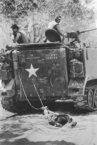 Soldados americanos arrastran a un norvietnamita durante la guerra de Vietnam