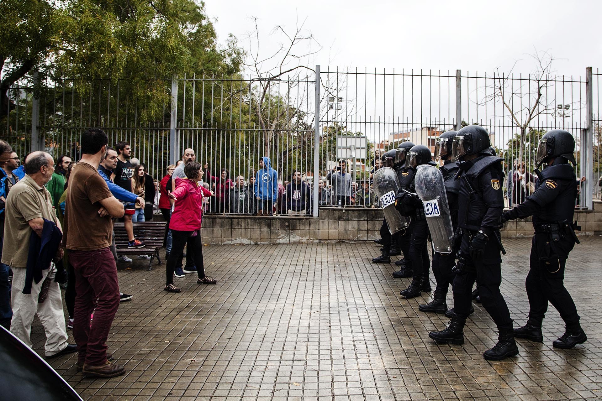 Members of the National Police of the Spanish State are facing citizens who exercise their right to vote during an operation to requisition ballot boxes at a polling station in Barcelona.