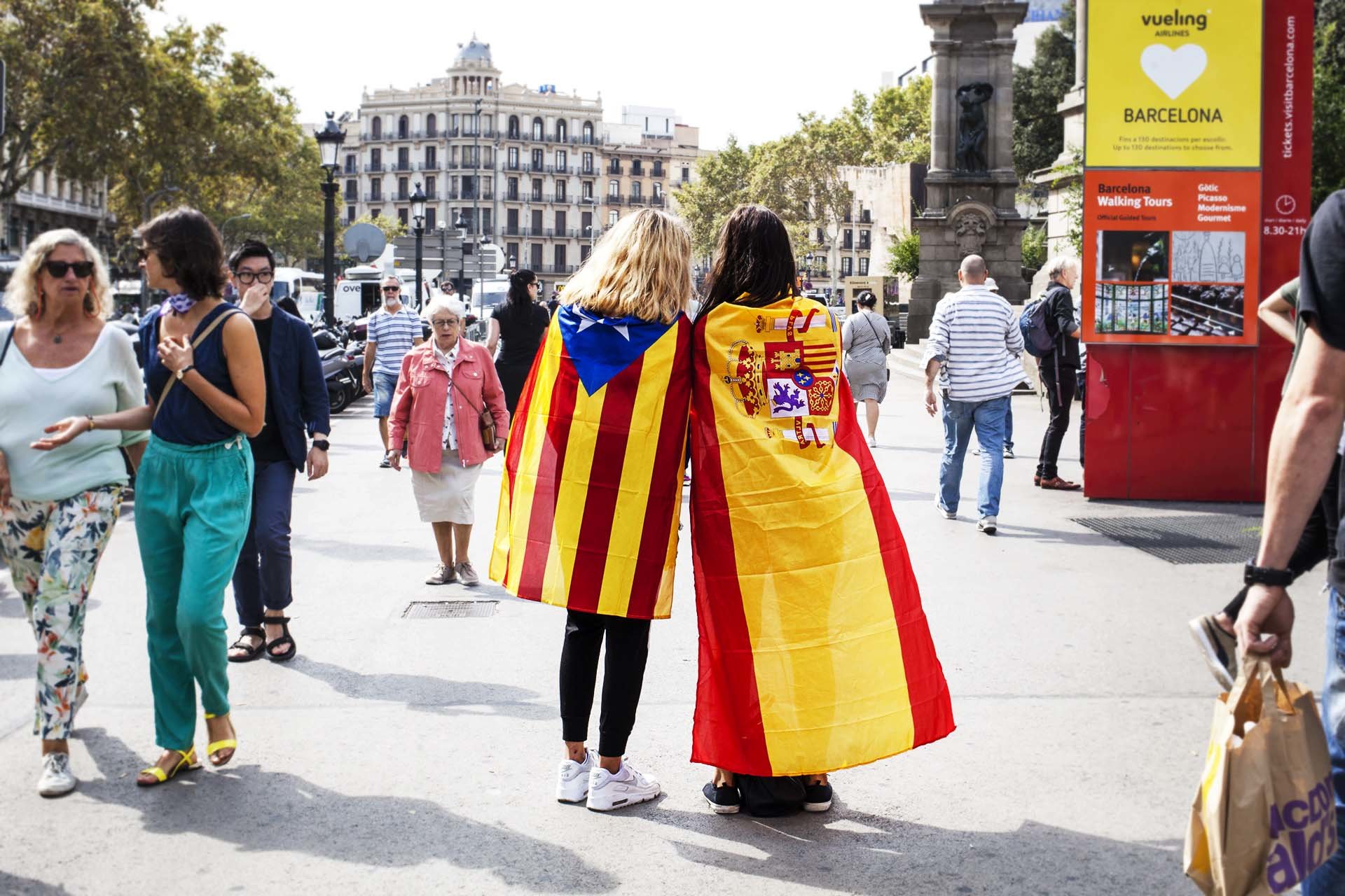Two girls with the Catalan and Spanish flag each, in the Plaza de Catalunya in Barcelona, the day before the historic referendum of self-determination