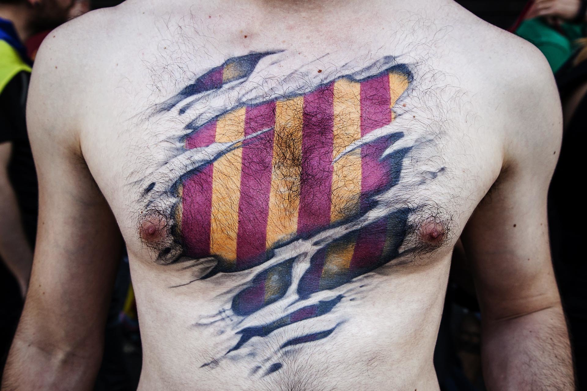 Protester in a demonstration for the police brutality lived in the referendum of 1 October for the independence of Catalonia, with a tattooed catalan flag.